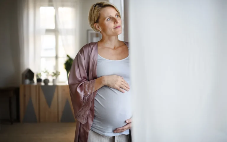 Femme enceinte sereine près d'une fenêtre