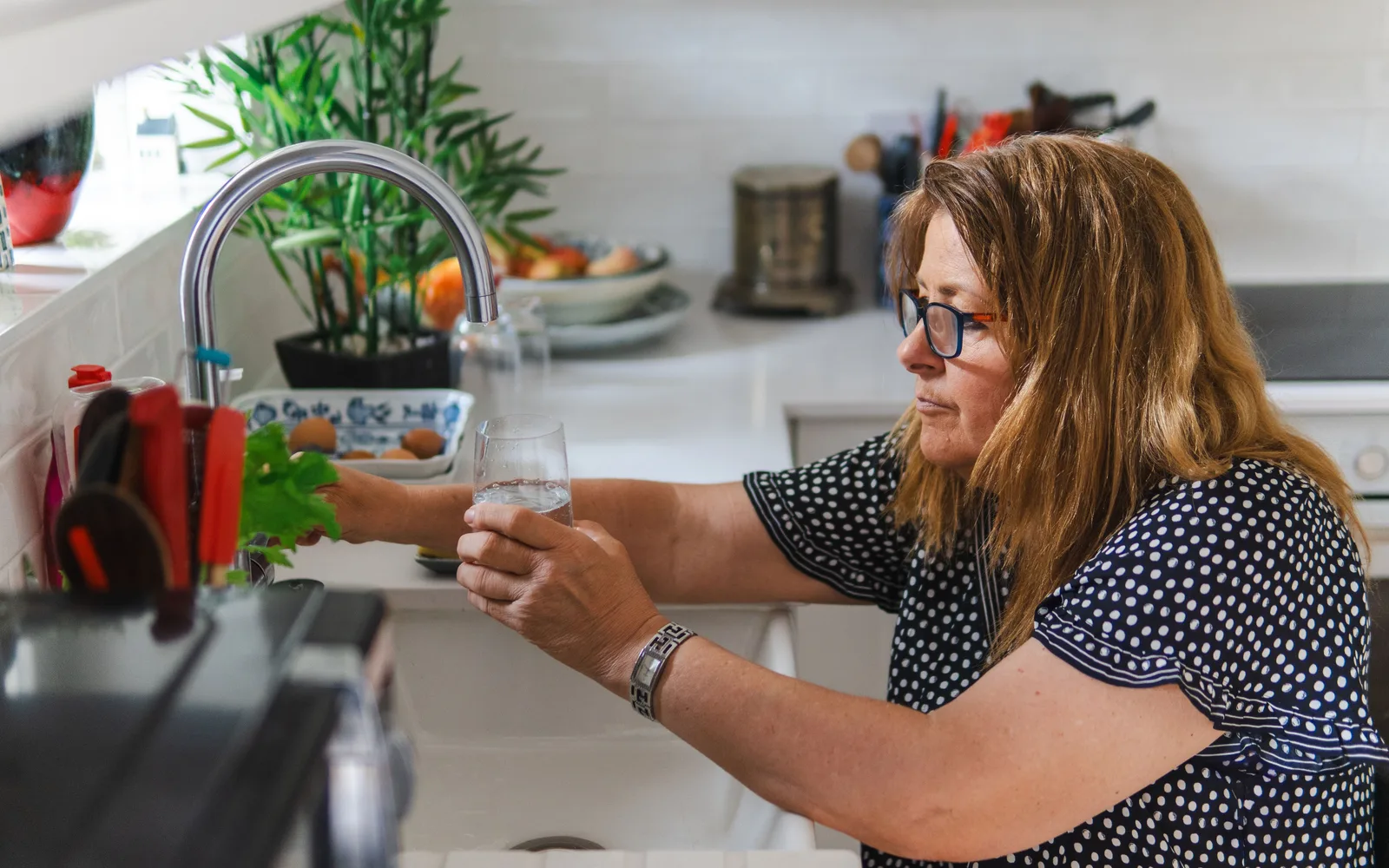 Femme remplissant un verre d'eau