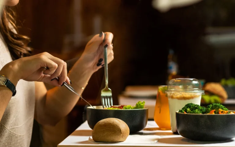 Femme attablée devant une salade de légumes