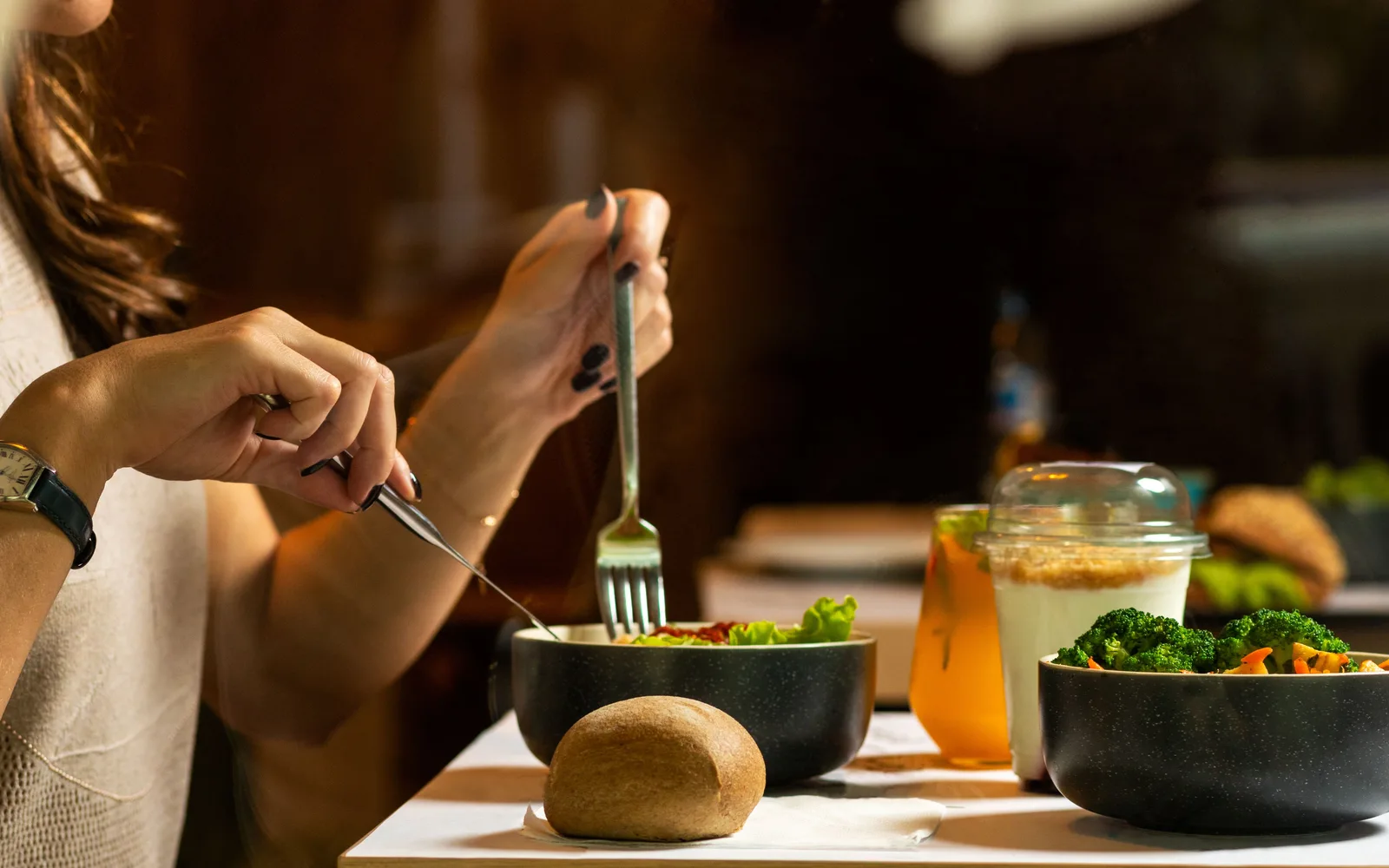 Femme attablée devant une salade de légumes