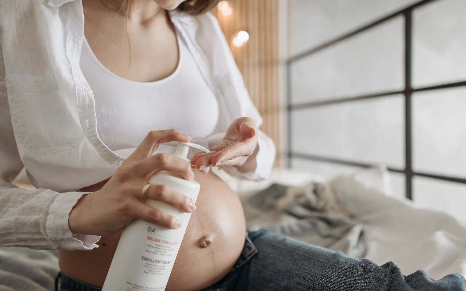 Femme enceinte appliquant une huile sur son ventre