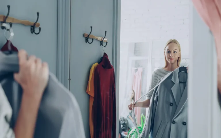 Femme choisissant une veste devant un miroir