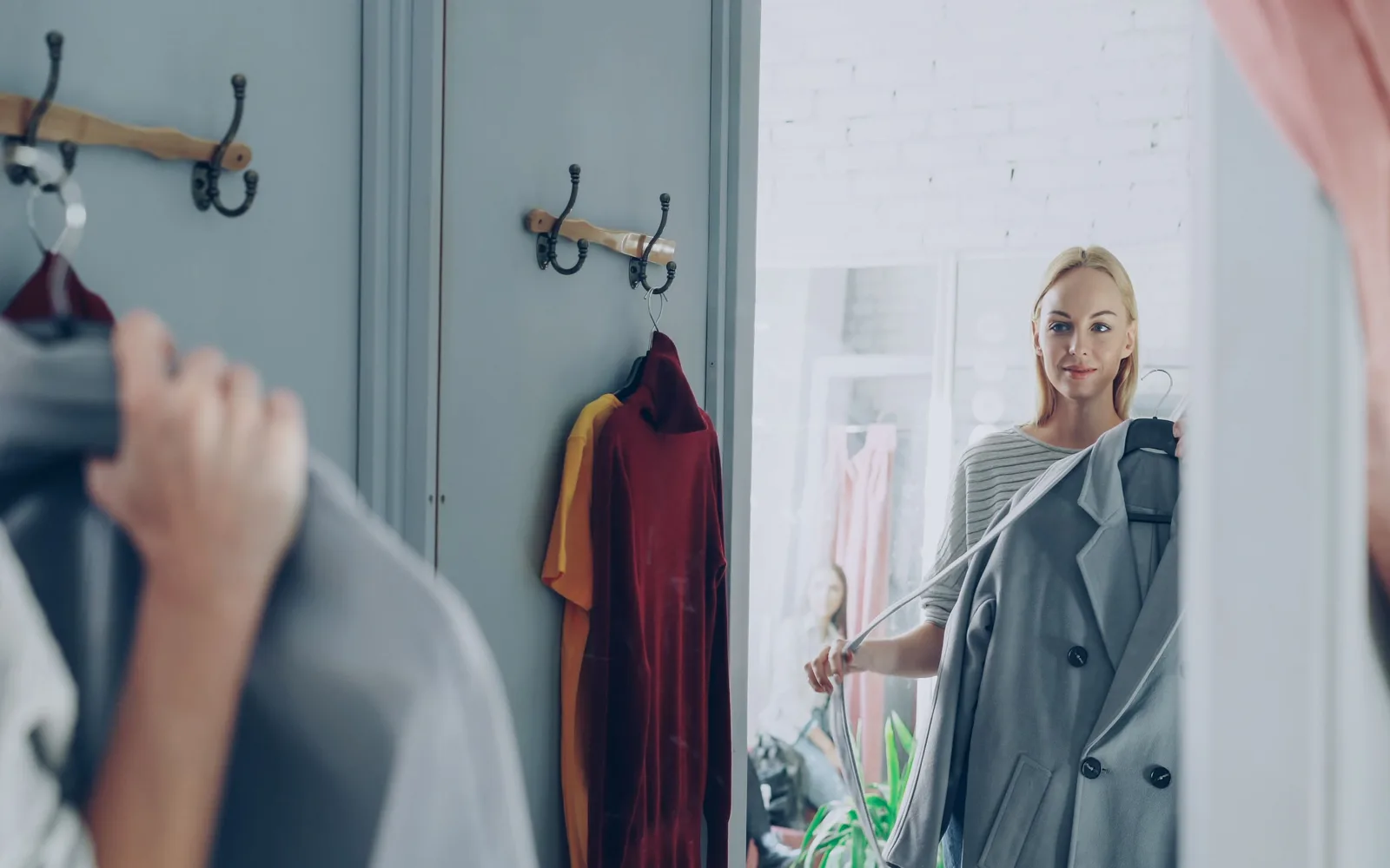 Femme choisissant une veste devant un miroir